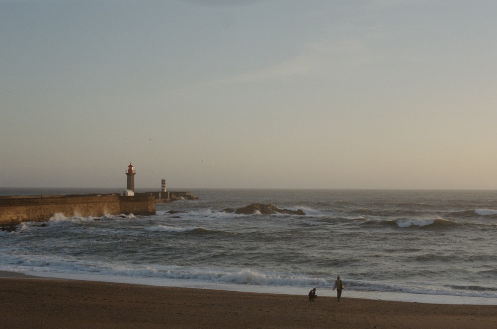 Un par de personas de pie en la cima de una playa de arena