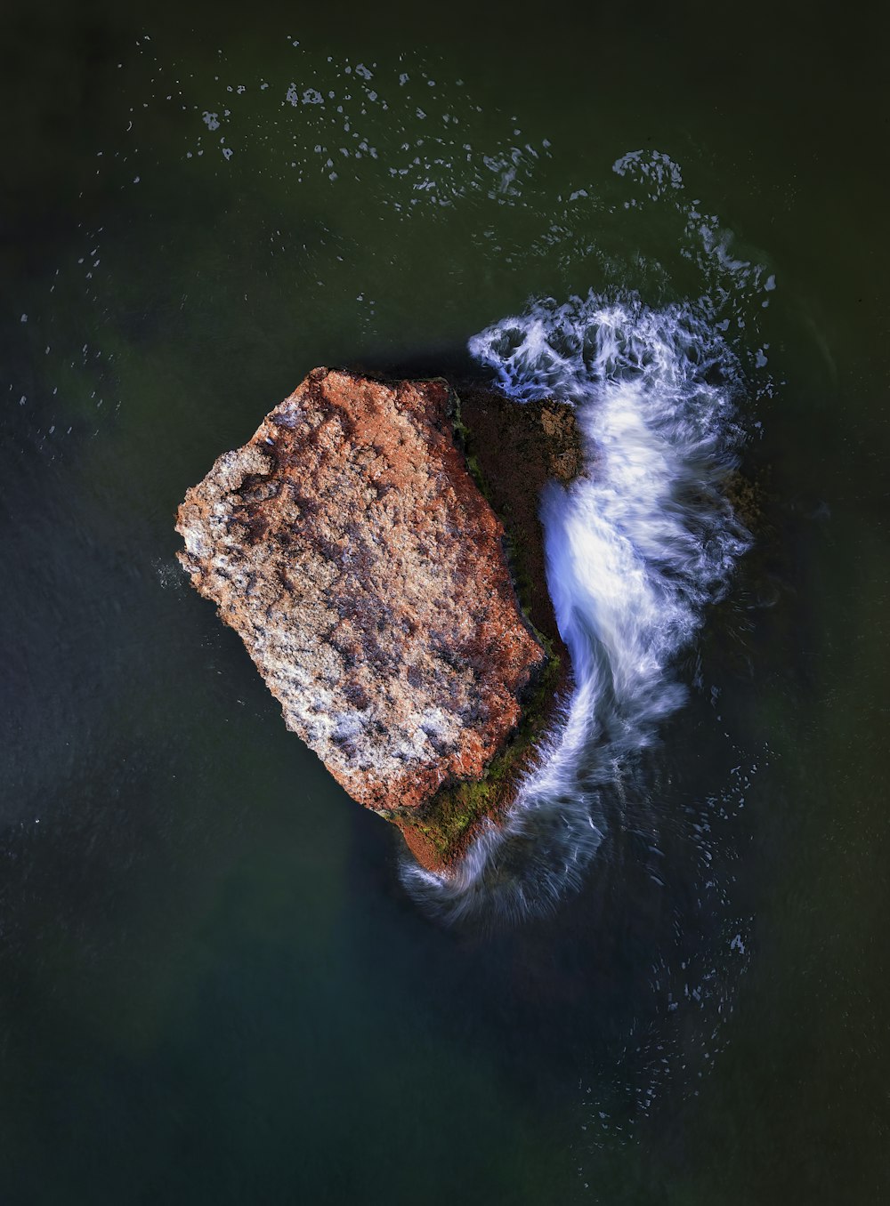 a rock in the middle of a body of water