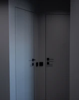 Matte black door handle mounted on a minimalist white door, highlighting its smooth finish.