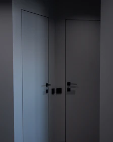 Modern wardrobe with glossy white doors and minimalist handles.