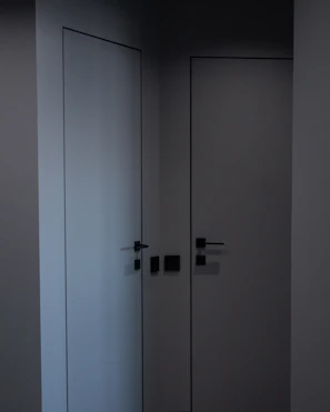 Matte black door handle mounted on a minimalist white door, highlighting its smooth finish.