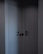 Two minimalist, modern doors with sleek black handles set in a dark corner, casting subtle shadows. The walls and doors have a smooth, matte finish, contributing to a clean, contemporary look.