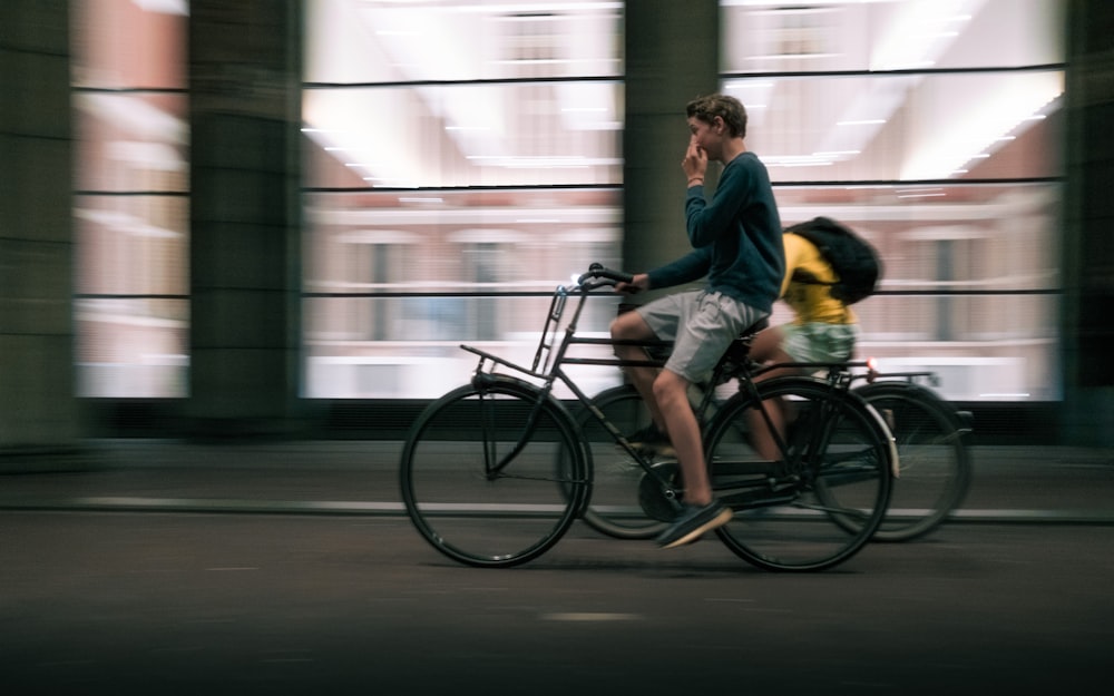 a man riding a bike while talking on a cell phone