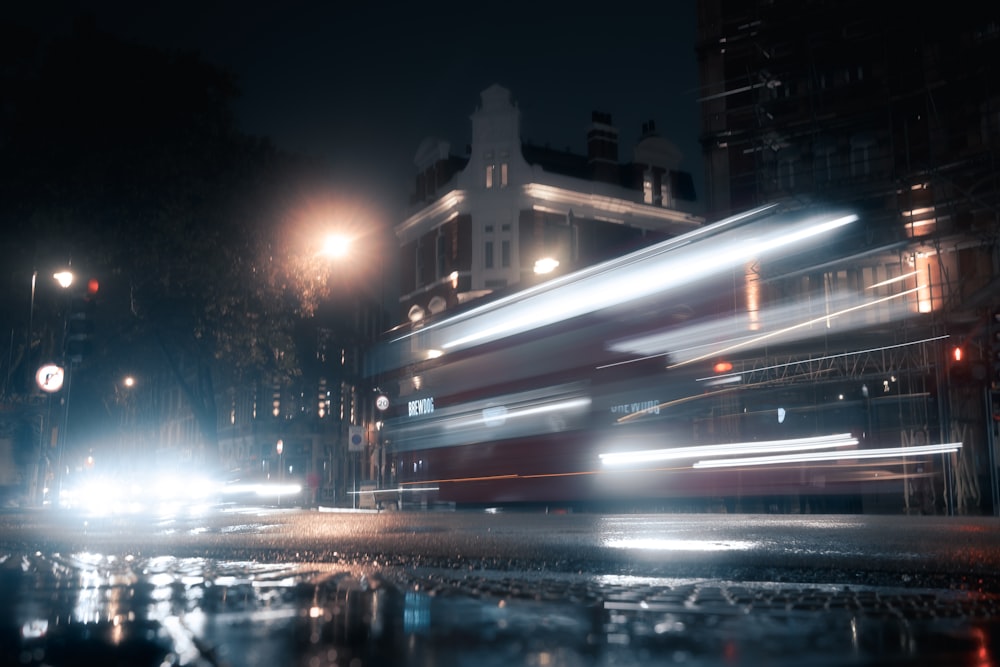 a double decker bus driving down a street at night