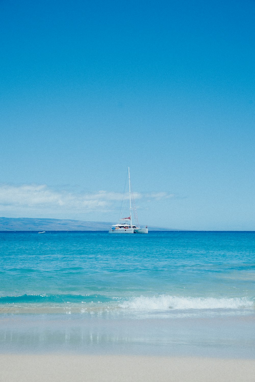 a sailboat in the ocean on a sunny day