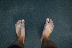 a person standing in the sand with their feet in the sand