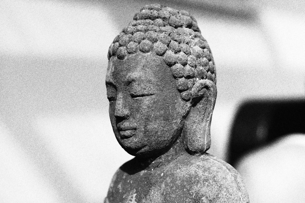 a black and white photo of a buddha statue