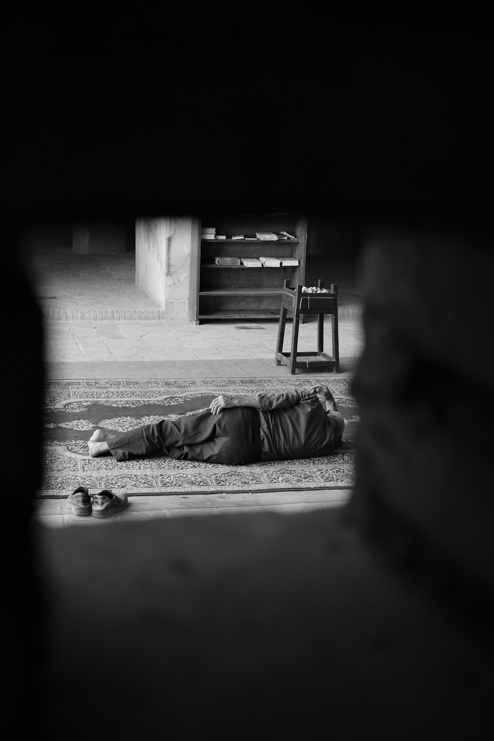 a person laying on the ground in front of a chair