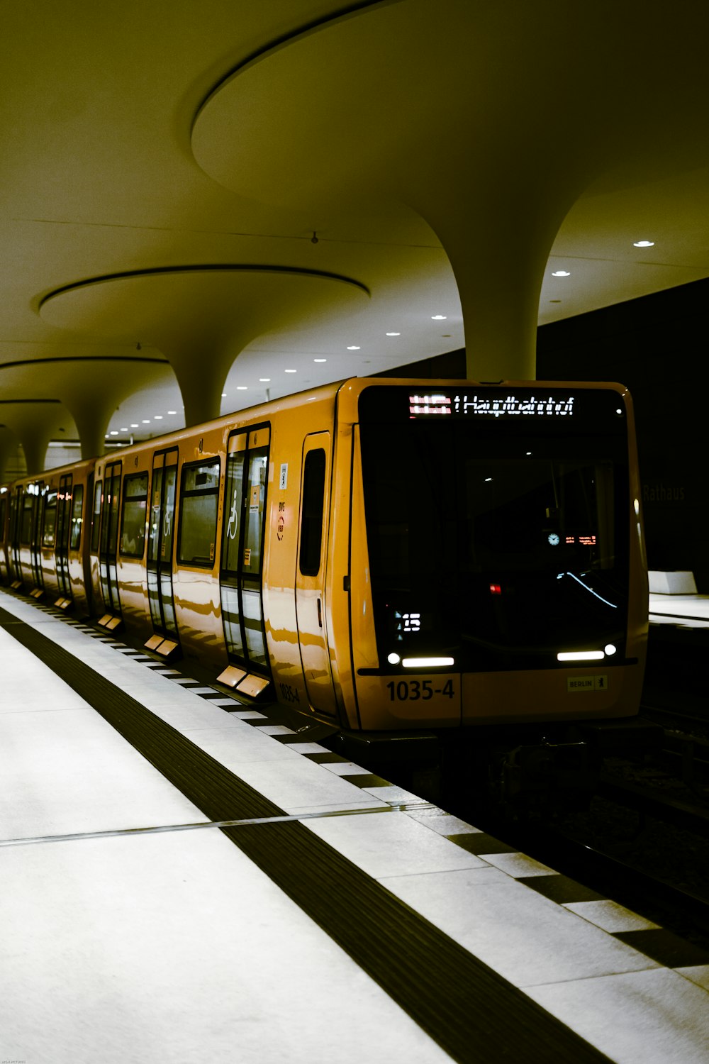 a yellow train pulling into a train station