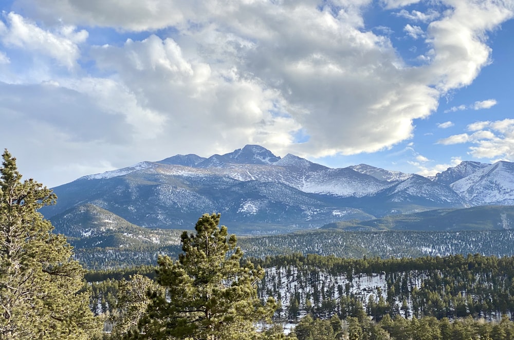 a view of a mountain range with trees and mountains in the background