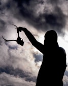 A proud hunter holding a trophy whitetail deer against the backdrop of Texas plains at sunset.