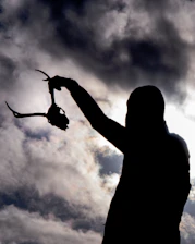 Close-up of a hunter’s joyful expression holding a freshly hunted trophy against a sunset backdrop.
