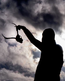 Close-up of a hunter’s joyful expression holding a freshly hunted trophy against a sunset backdrop.