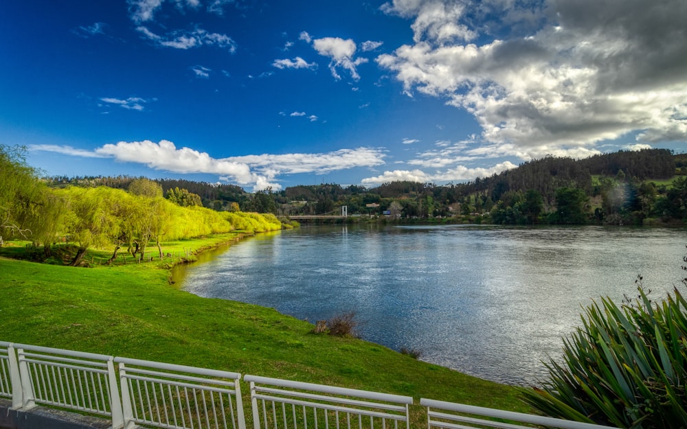 a beautiful view of a lake and a white fence