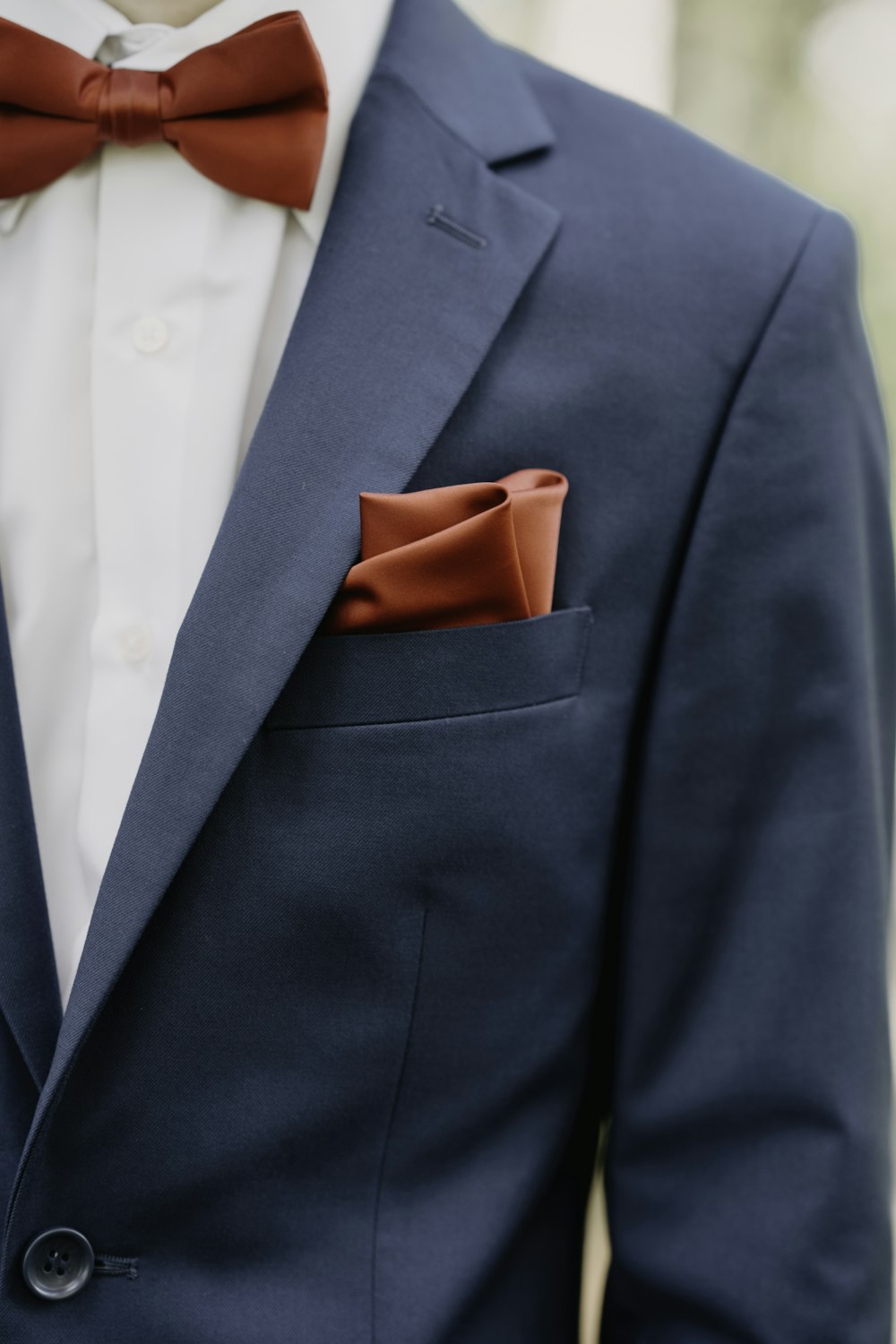 a man wearing a blue suit with a brown bow tie