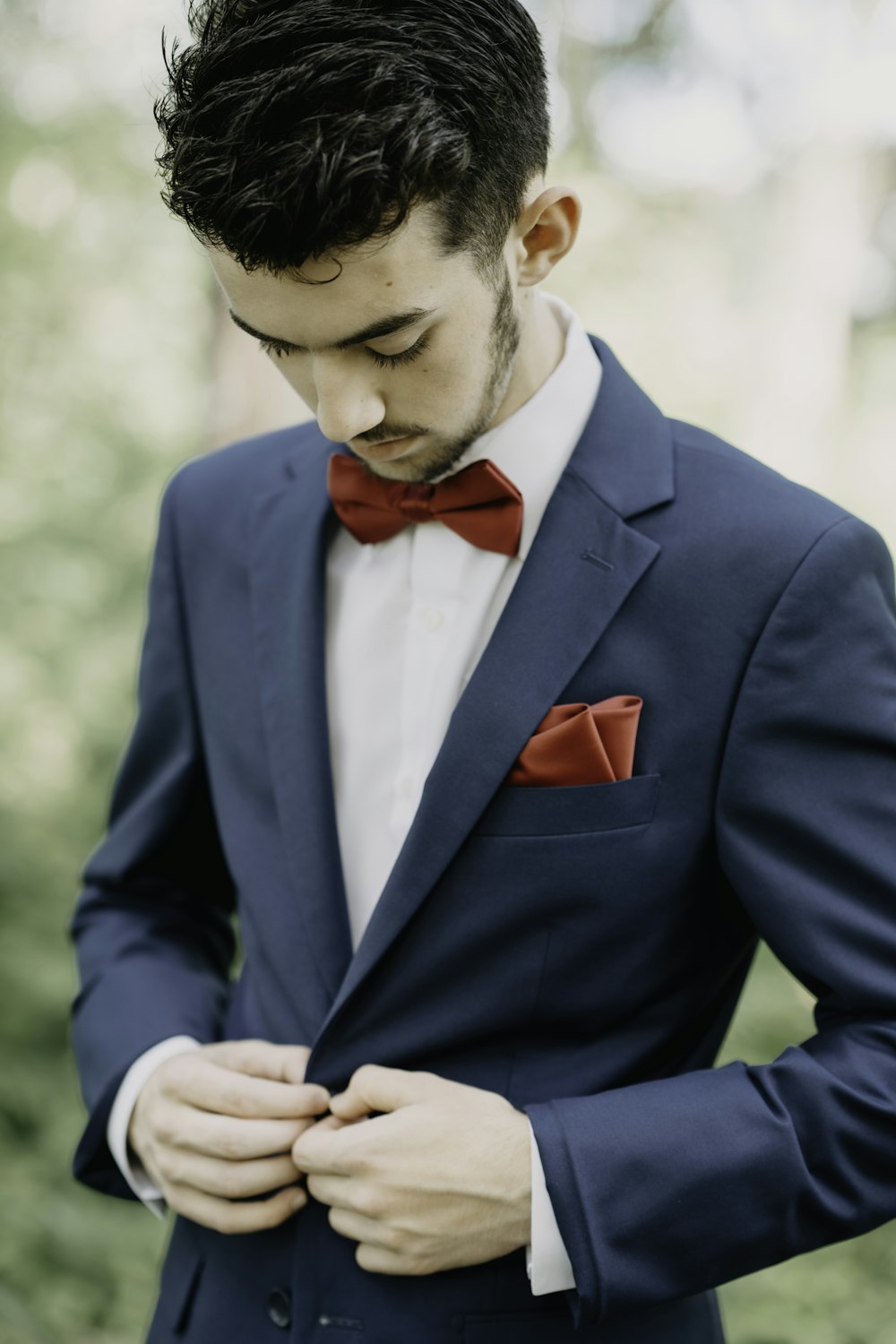 a man in a blue suit with a red bow tie