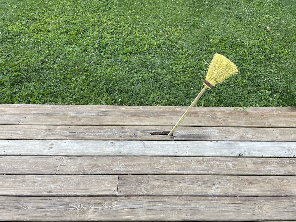 a broom sitting on top of a wooden deck