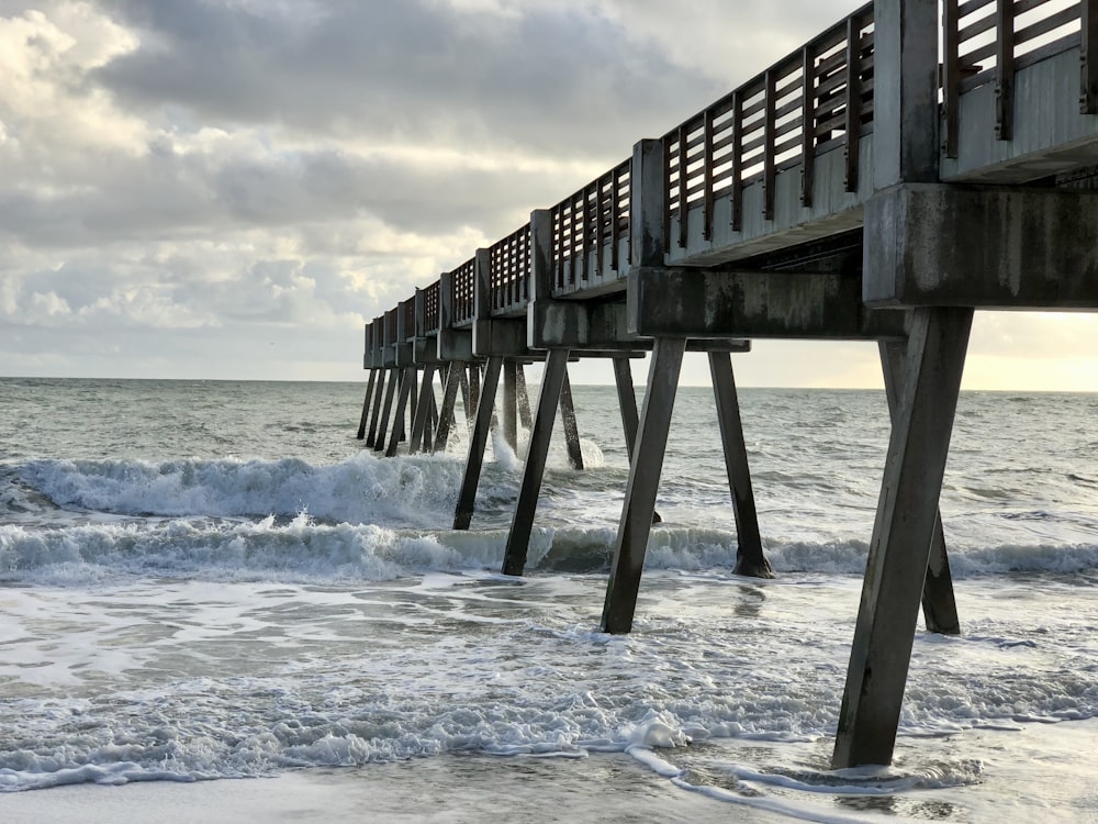 a long pier stretches out into the ocean