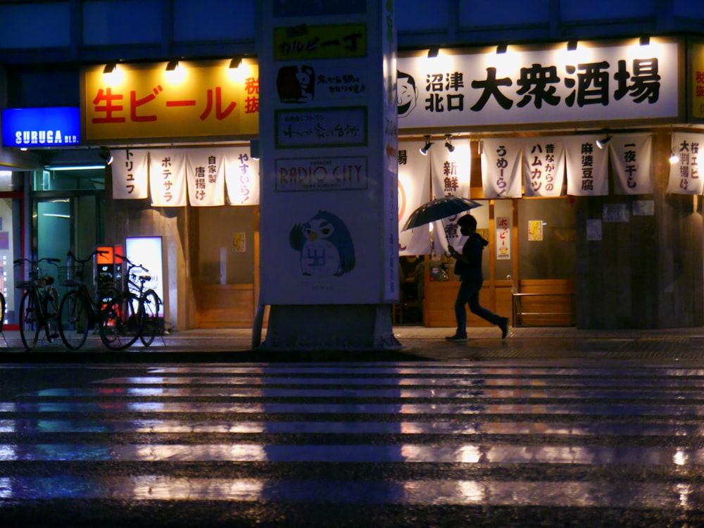 a woman walking down a street holding an umbrella