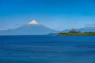 a large body of water with a mountain in the background