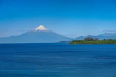 a large body of water with a mountain in the background