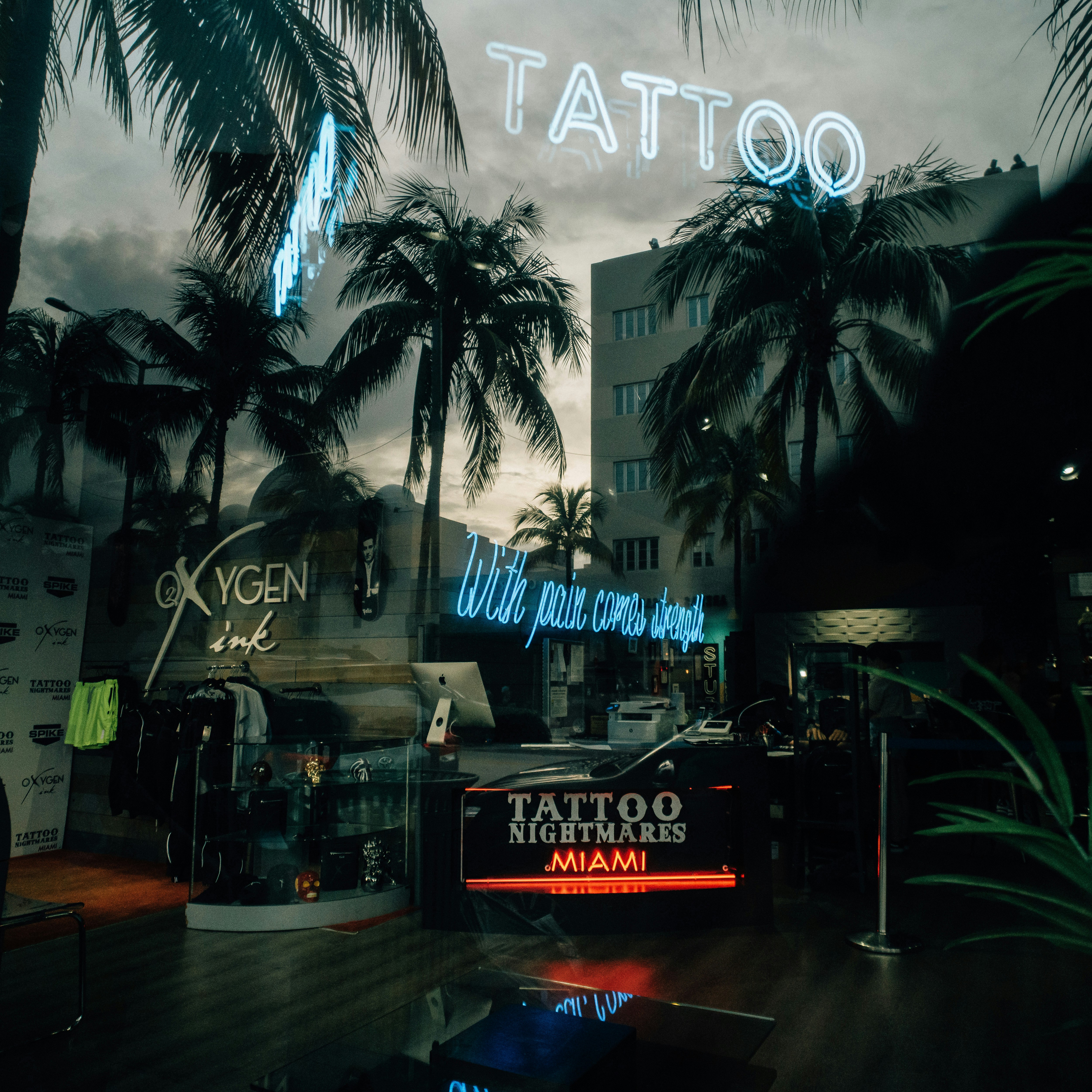 a tattoo shop with palm trees in the background