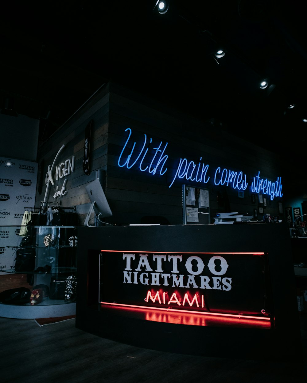 a tattoo shop with neon signs on the wall
