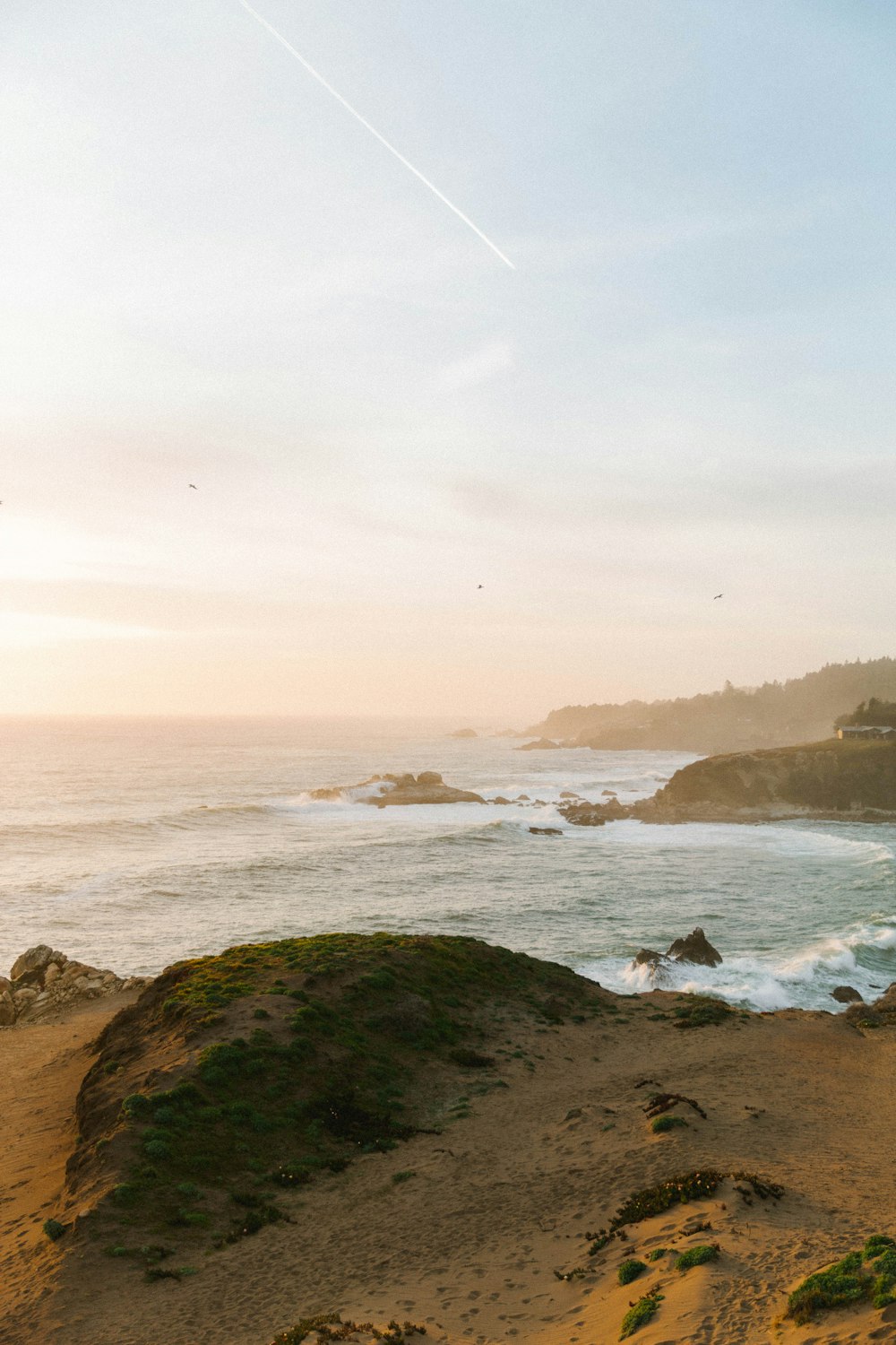 a view of the ocean from a sandy beach