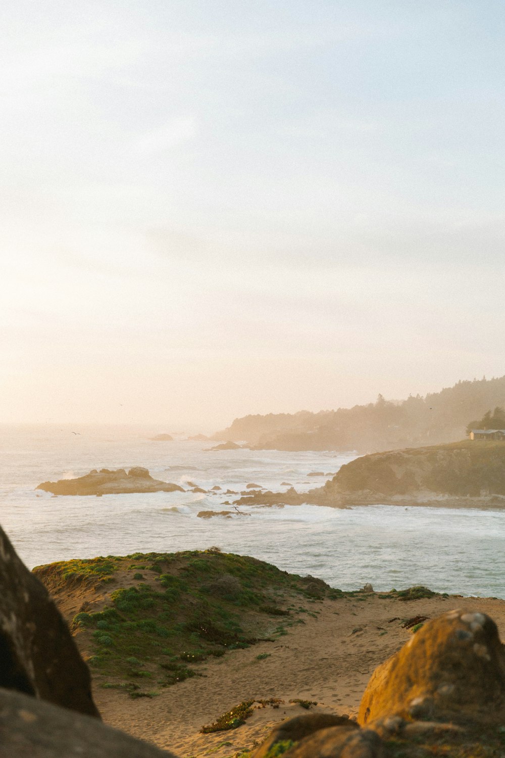 a person sitting on a rock looking out at the ocean