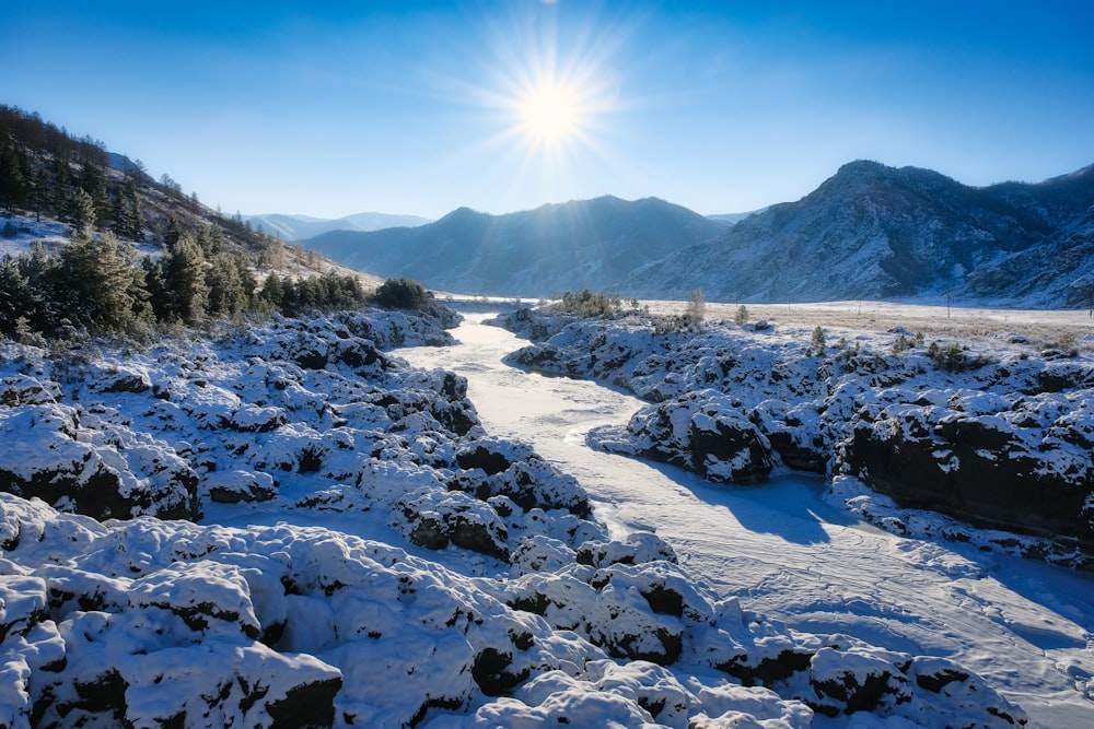 the sun shines brightly over a snowy landscape