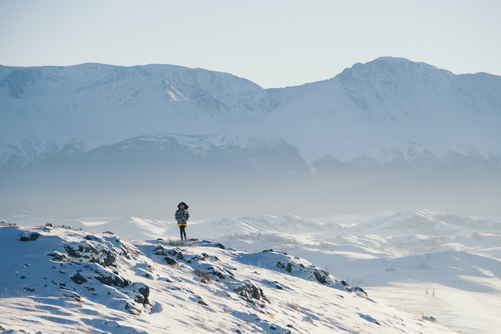 a person standing on top of a snow covered mountain