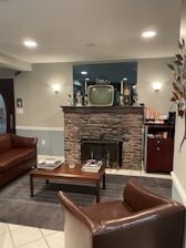 A cozy family living room with a vintage video player and framed photos on the wall.