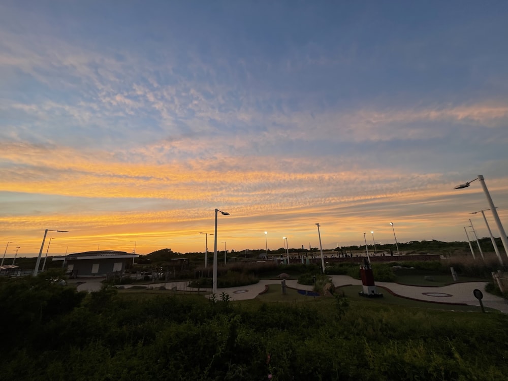 a sunset view of a skate park with a skateboard park in the foreground