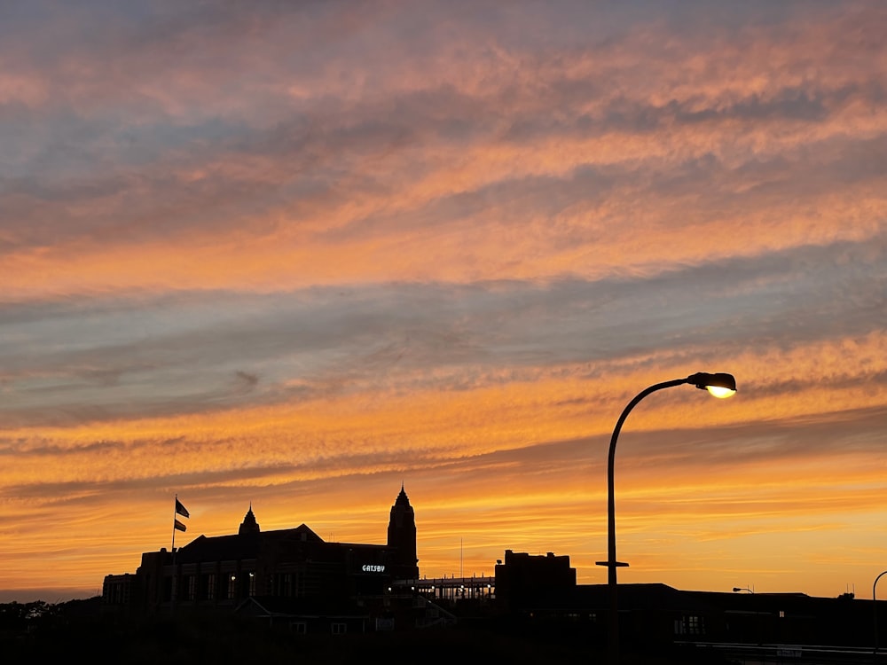 a sunset view of a street light and a building