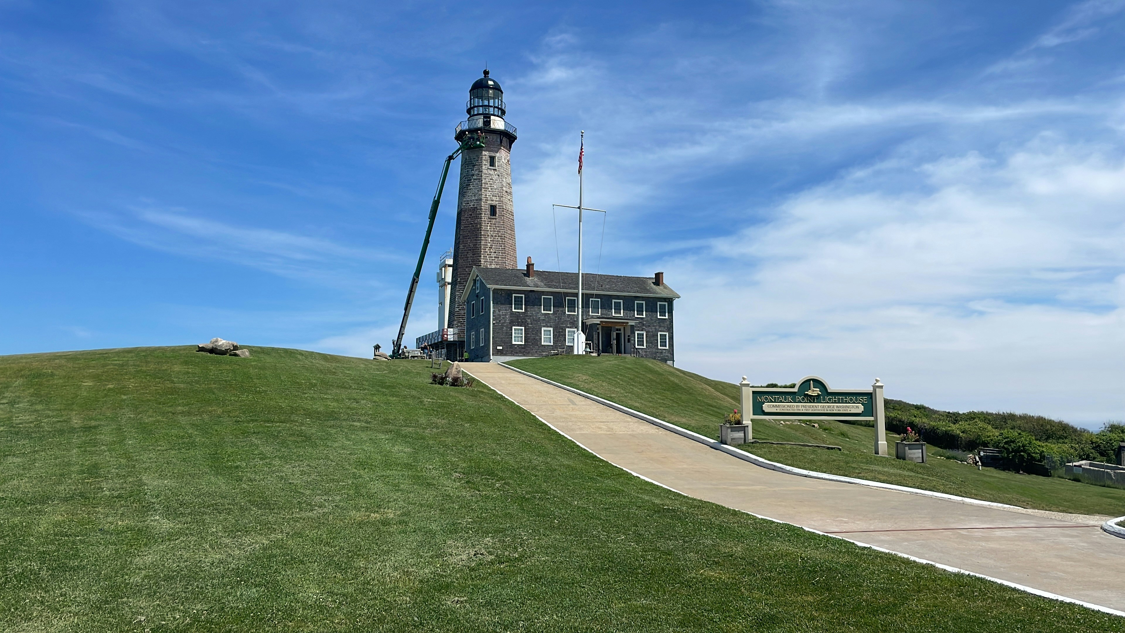 a lighthouse on top of a grassy hill