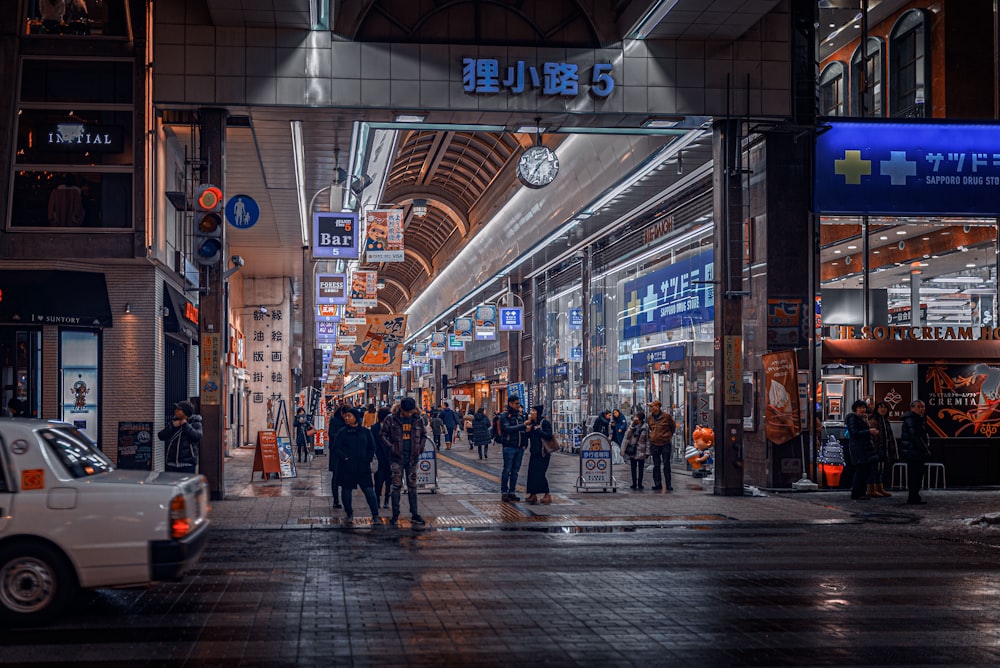 a group of people walking down a street next to tall buildings