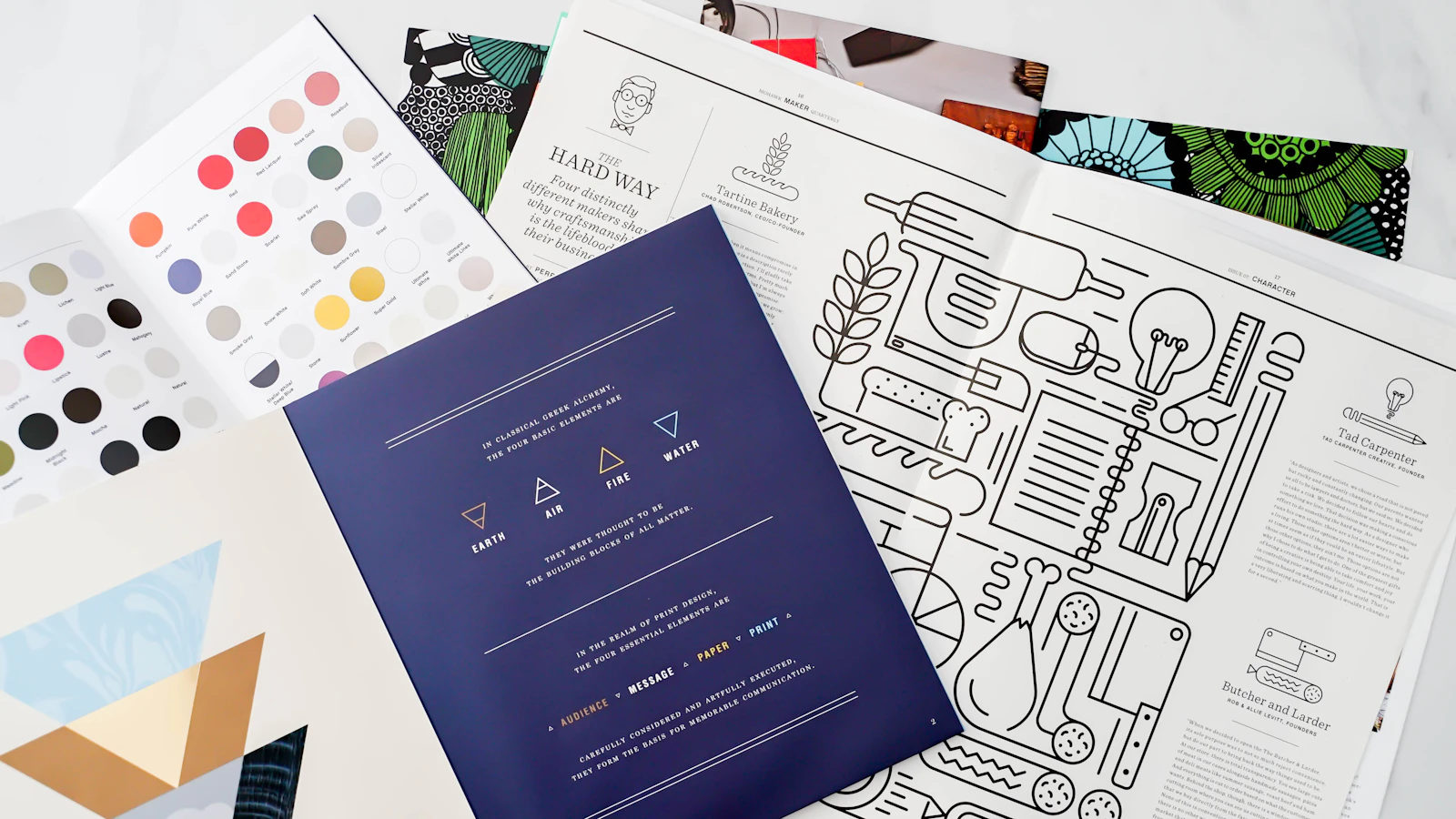 Printed design sketches and papers spread across a table