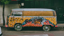 a van covered in graffiti parked on the side of the road