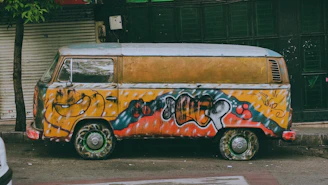 a van covered in graffiti parked on the side of the road