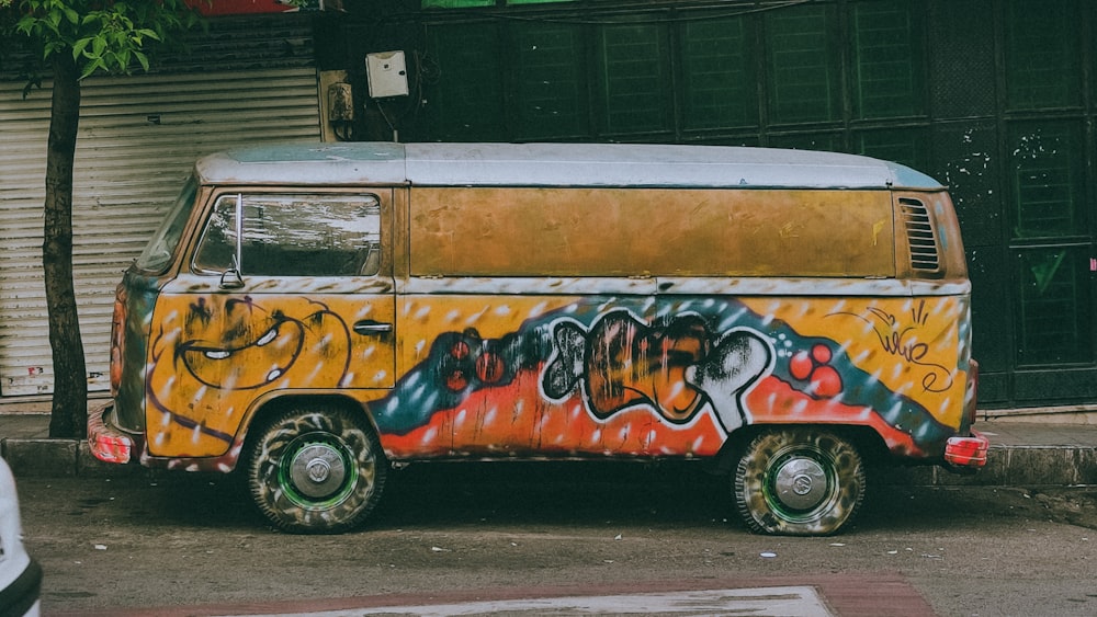 a van covered in graffiti parked on the side of the road