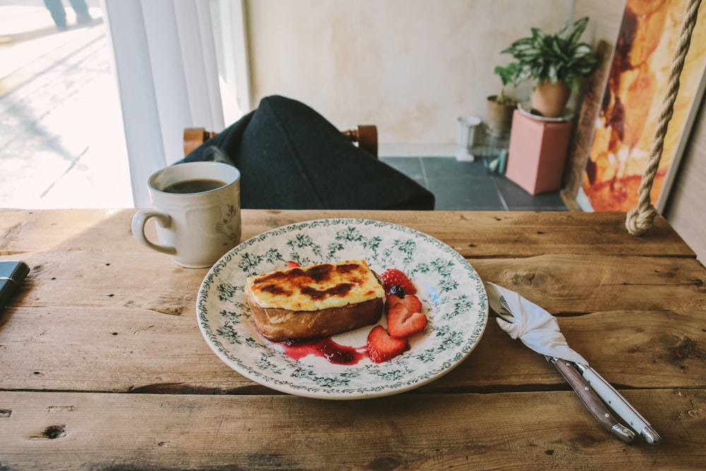 a plate of food on a table with a cup of coffee