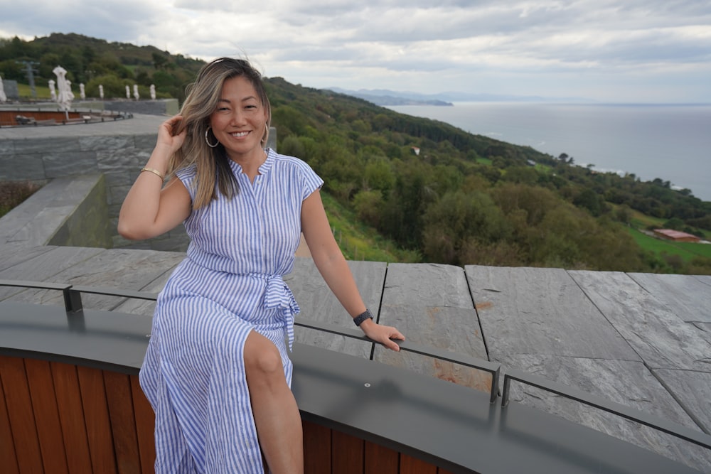 a woman in a blue dress standing on a balcony