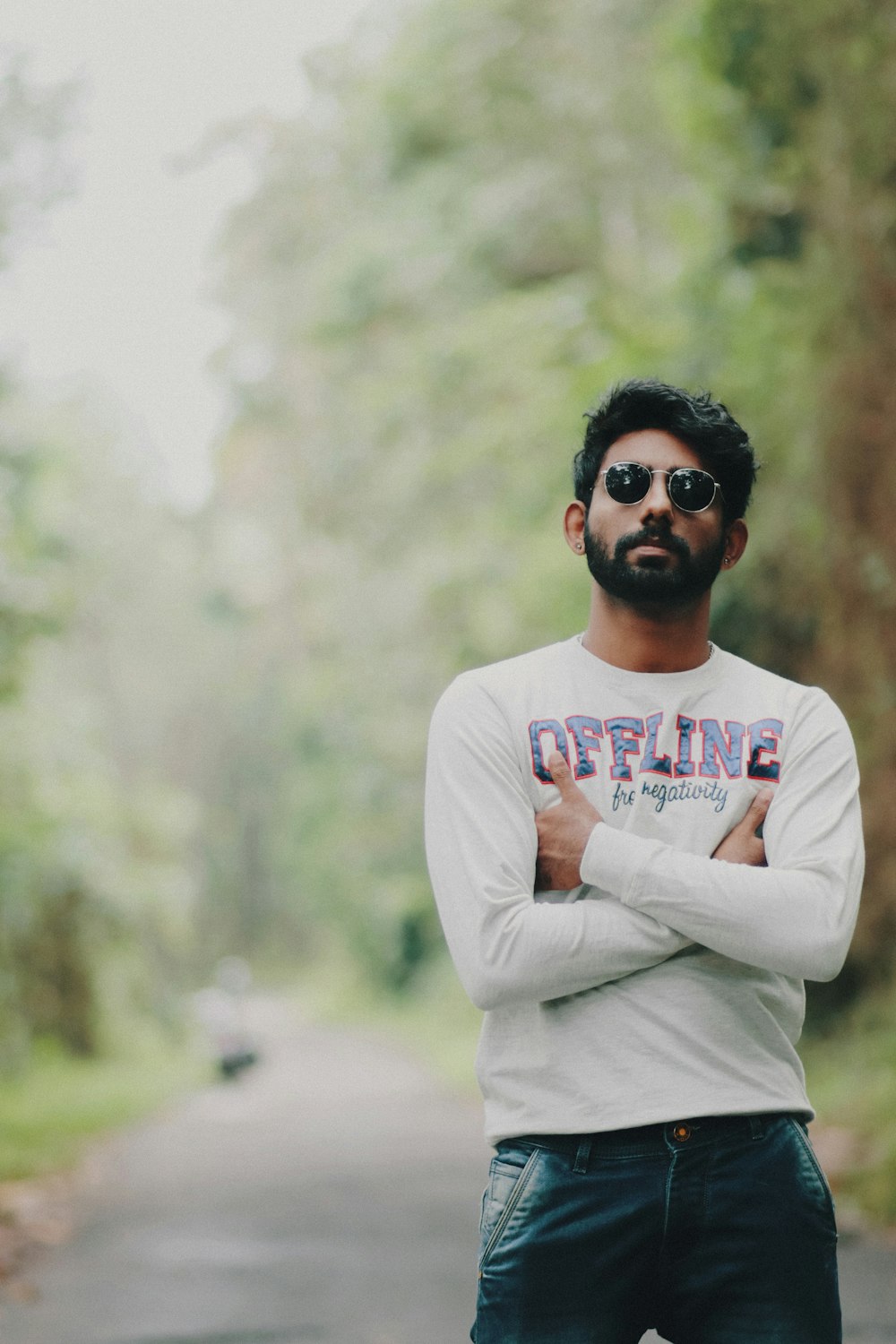 a man standing on a road with his arms crossed