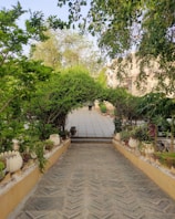 Close-up of intricate stone pavers arranged around a garden pathway with lush greenery.