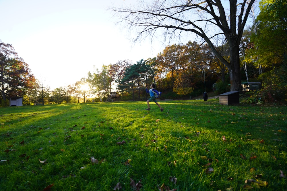 a person running across a lush green field