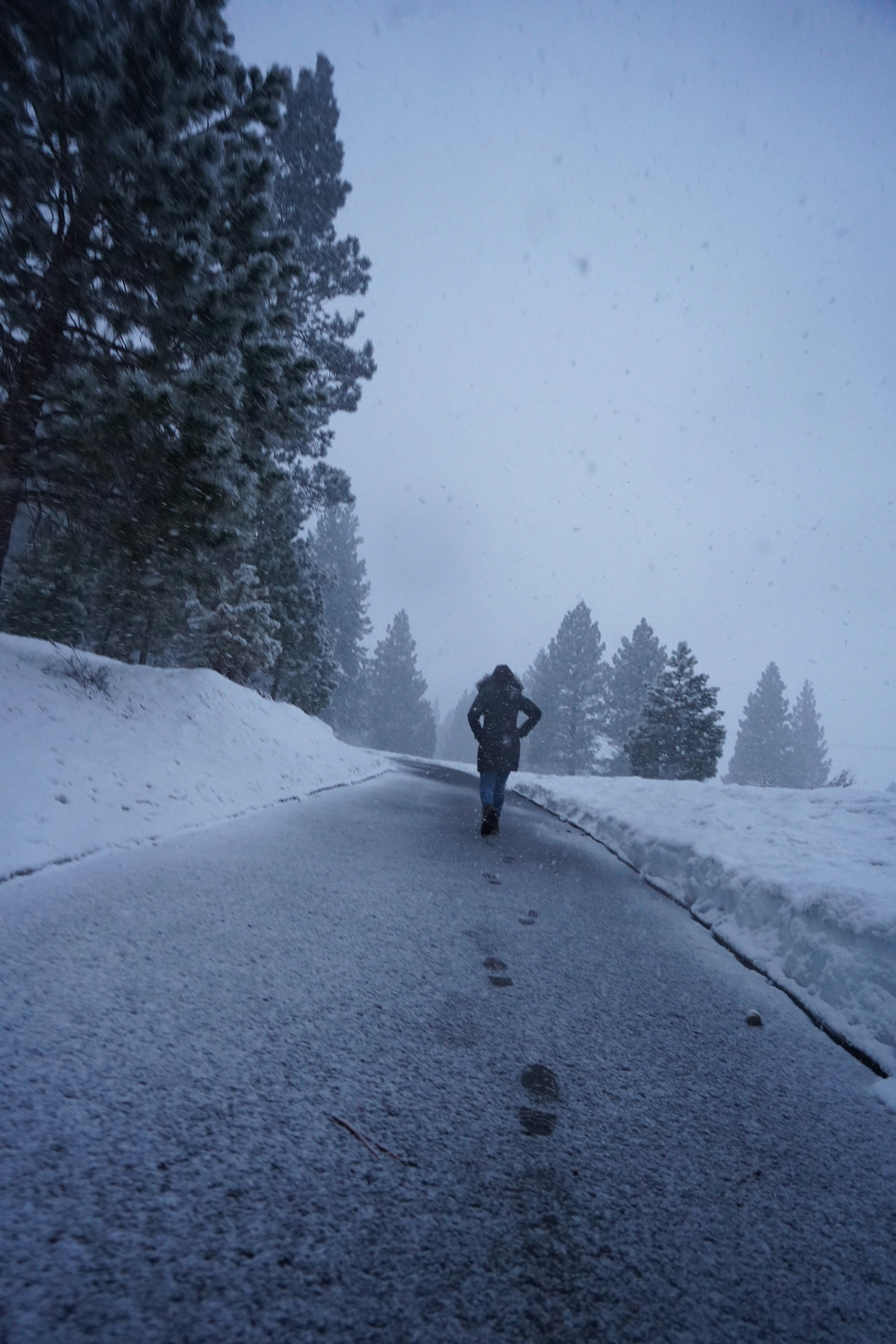 a person walking down a snow covered road