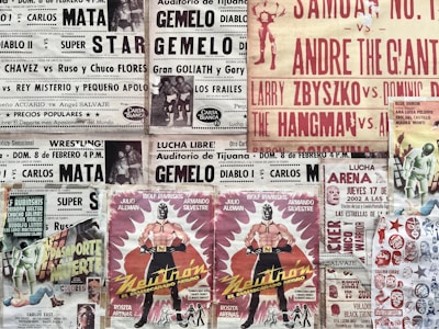 A collage of vintage wrestling posters featuring various luchadores and events. The posters are colorful, showcasing wrestlers in masks and promoting matches in bold, striking fonts. The designs include images of masked wrestlers and typography emphasizing the excitement of wrestling events.