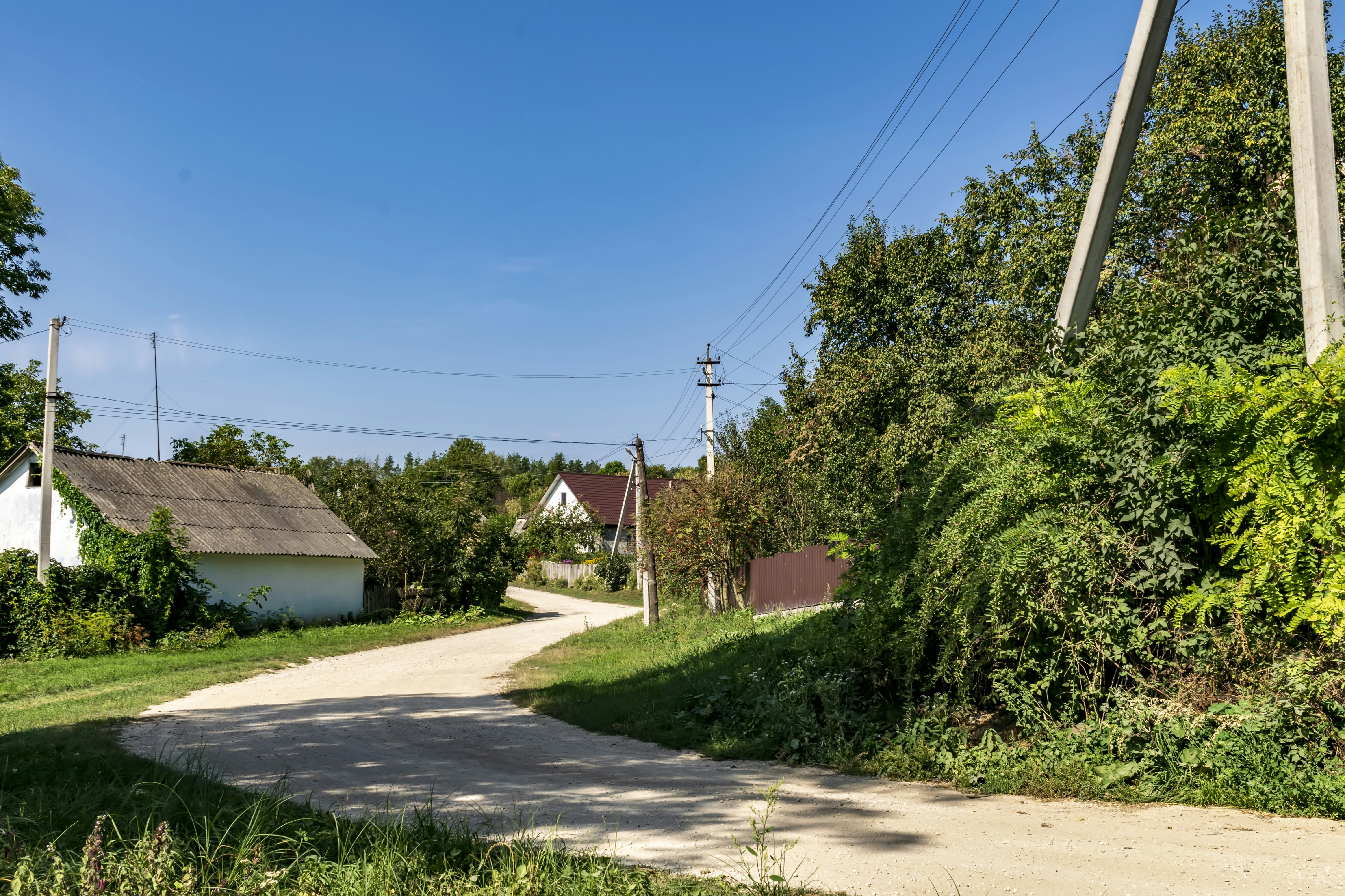 Une route rurale avec une maison en arrière-plan