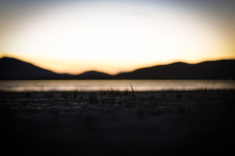 a blurry photo of the sun setting over a body of water