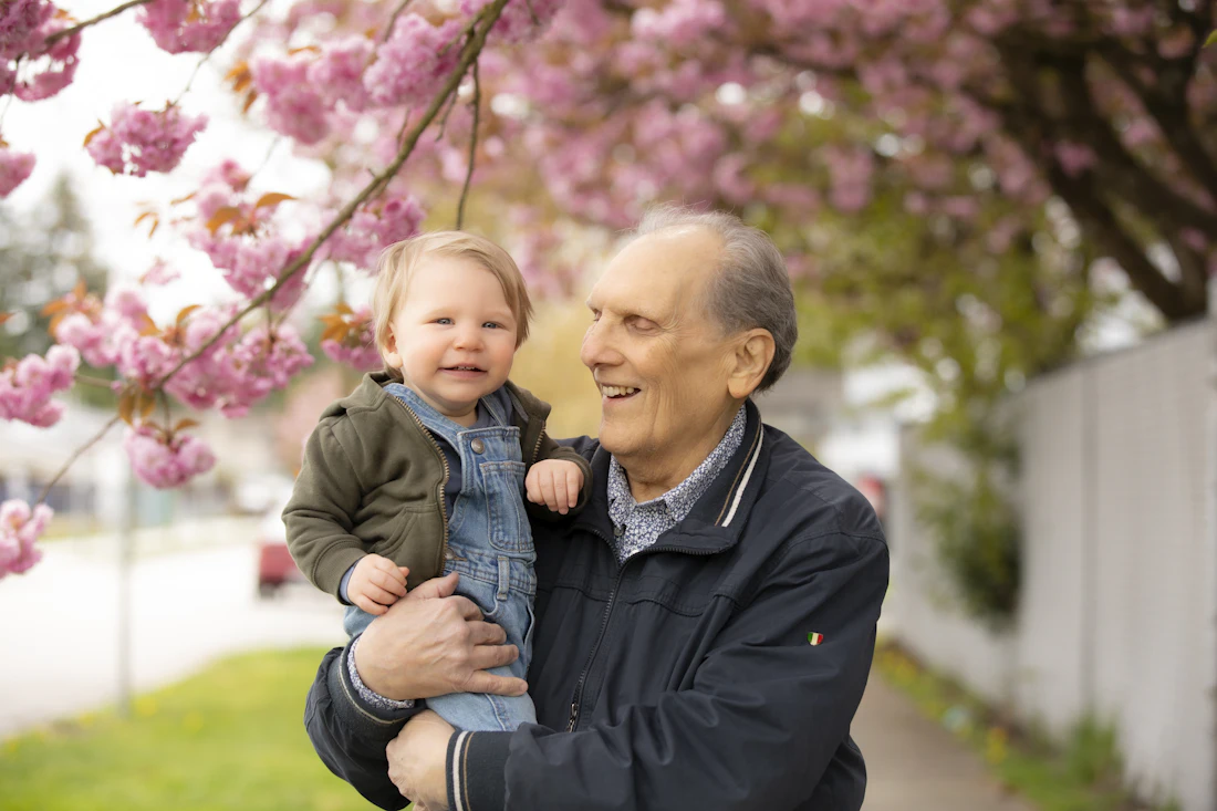 Un grand-père souriant tient son petit-fils dans ses bras
